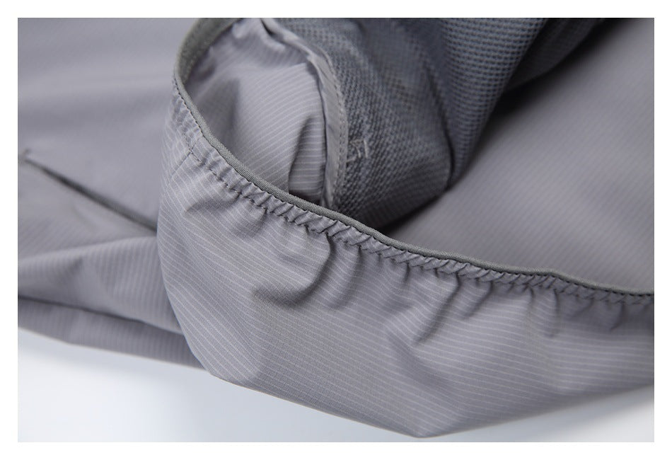 Close-up of a gathered, bound edge on a light gray garment with fine pinstripes.