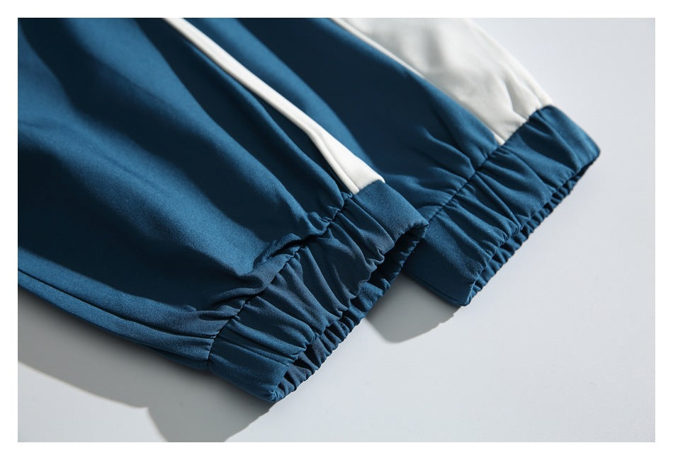 Close-up of gathered teal elastic cuffs with light-colored panels and narrow piping.