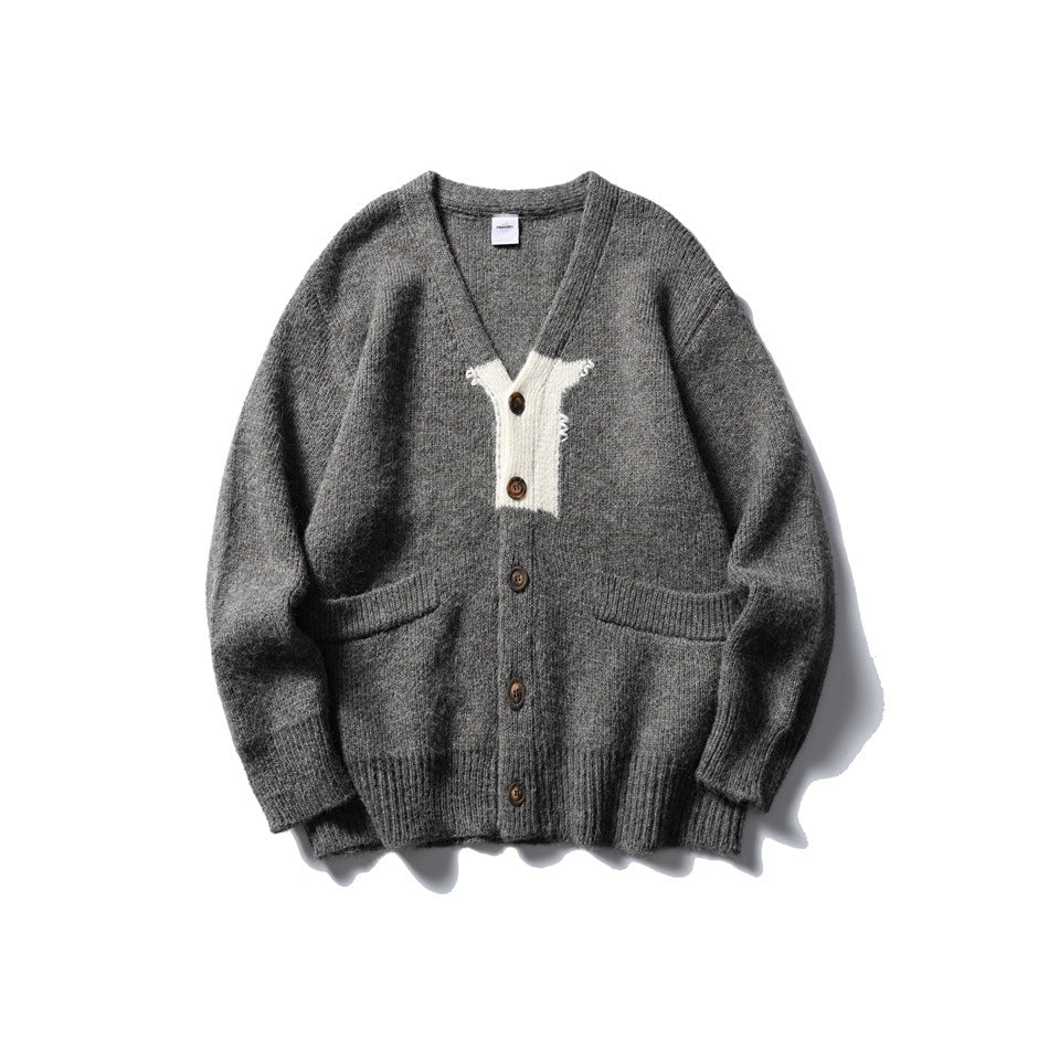 Gray knit V-neck cardigan with cream contrast chest panel, front buttons and two front pockets, flat lay