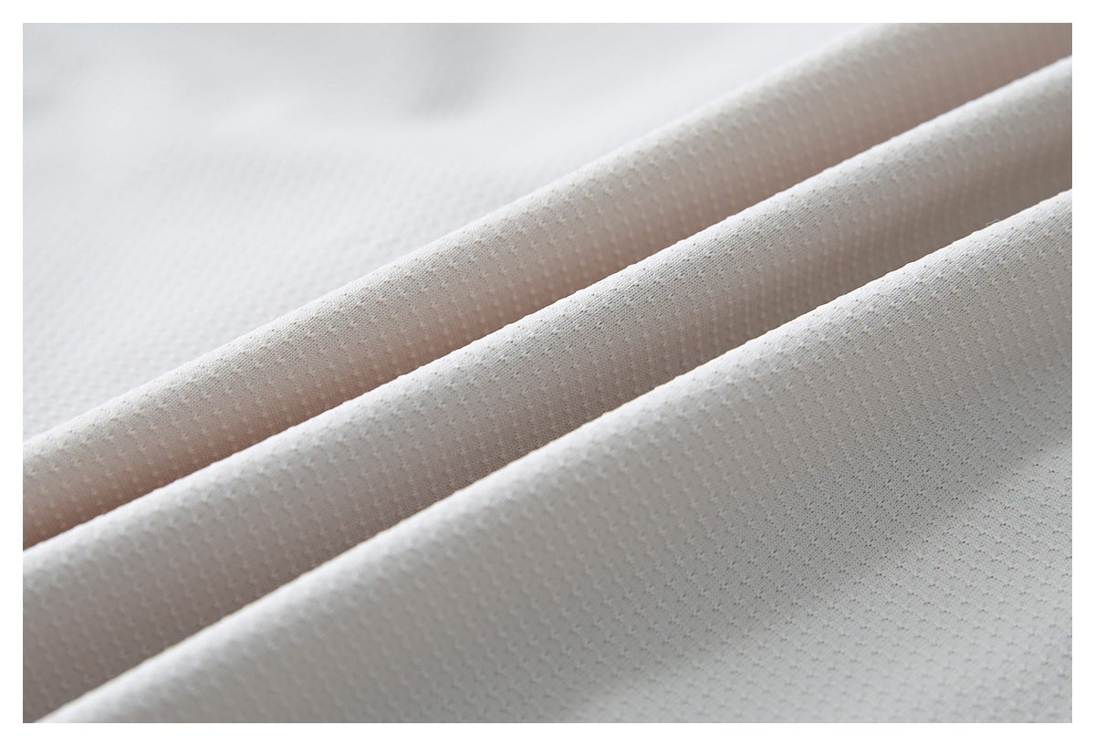 Close-up of white textured fabric folded into diagonal ridges.