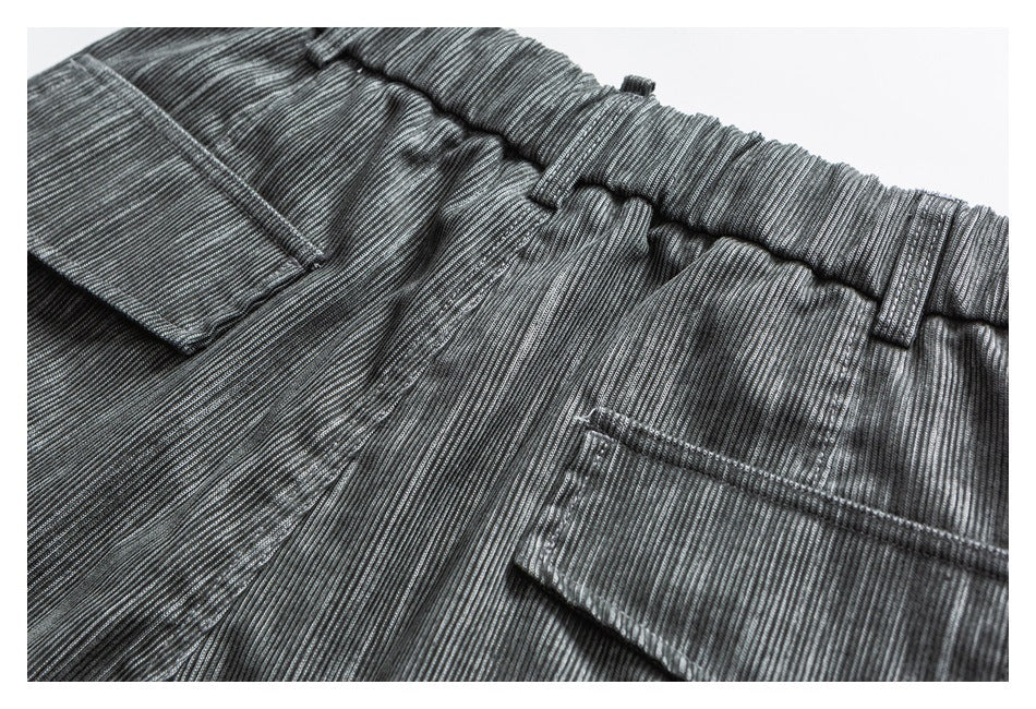 Close-up of gray striped trousers showing an elastic waistband, belt loops, and pockets.