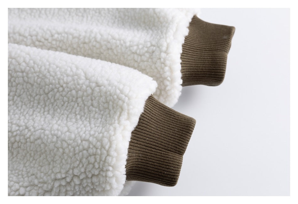 Close-up of a white sherpa jacket sleeve with a dark brown ribbed cuff.