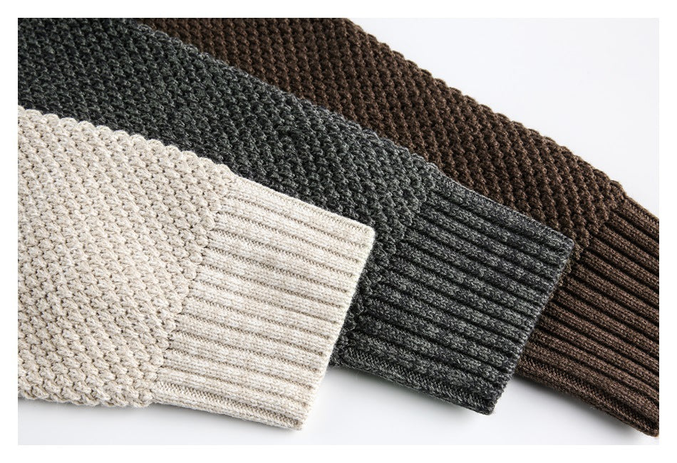 Close-up of ribbed sleeve cuffs on cream, charcoal gray, and brown textured knit sweaters.