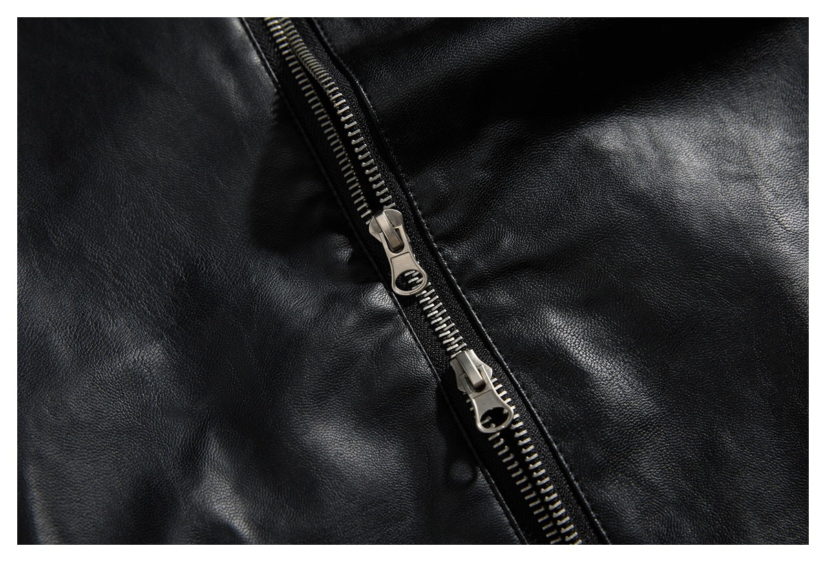 Close-up of a diagonal metal two-way zipper on black pebbled material.