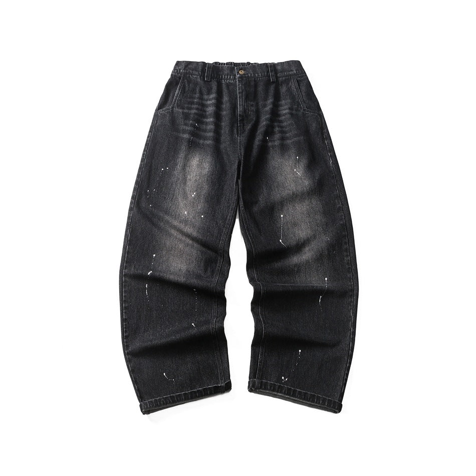 Black washed denim jeans with white paint splatters, wide straight legs and button fly, shown flat from the front
