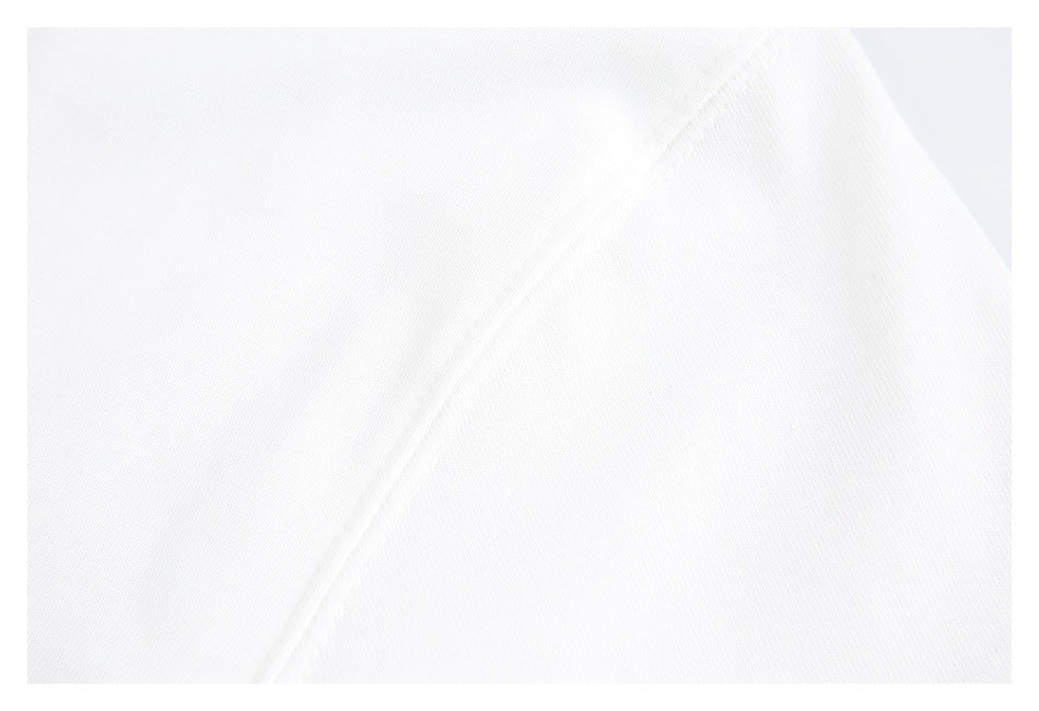Close-up of white fabric showing a diagonal seam and subtle knit texture.