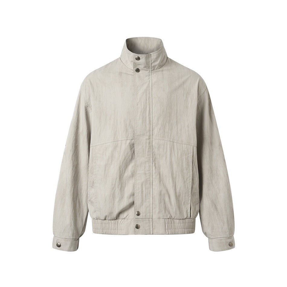 Beige stand-collar bomber-style jacket, front view, with snap placket, slanted pockets and elastic hem
