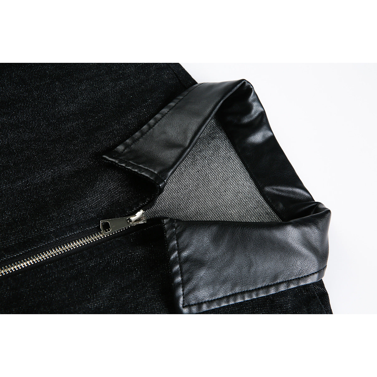 Close-up of a black jacket with a glossy faux-leather collar, textured fabric, and silver zipper.