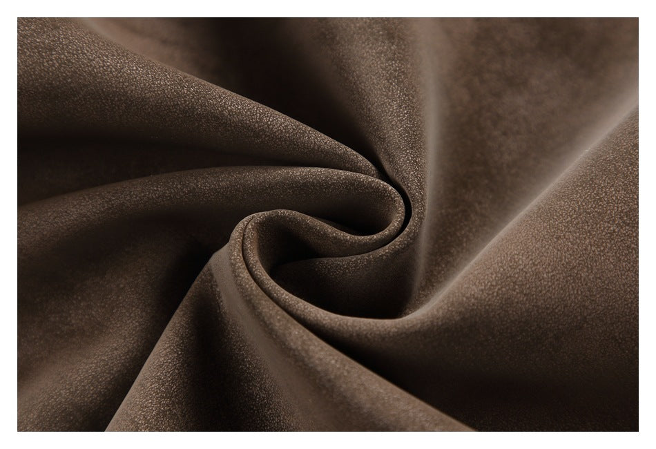 Close-up of brown fabric gathered into a swirl, showing its fine surface texture.