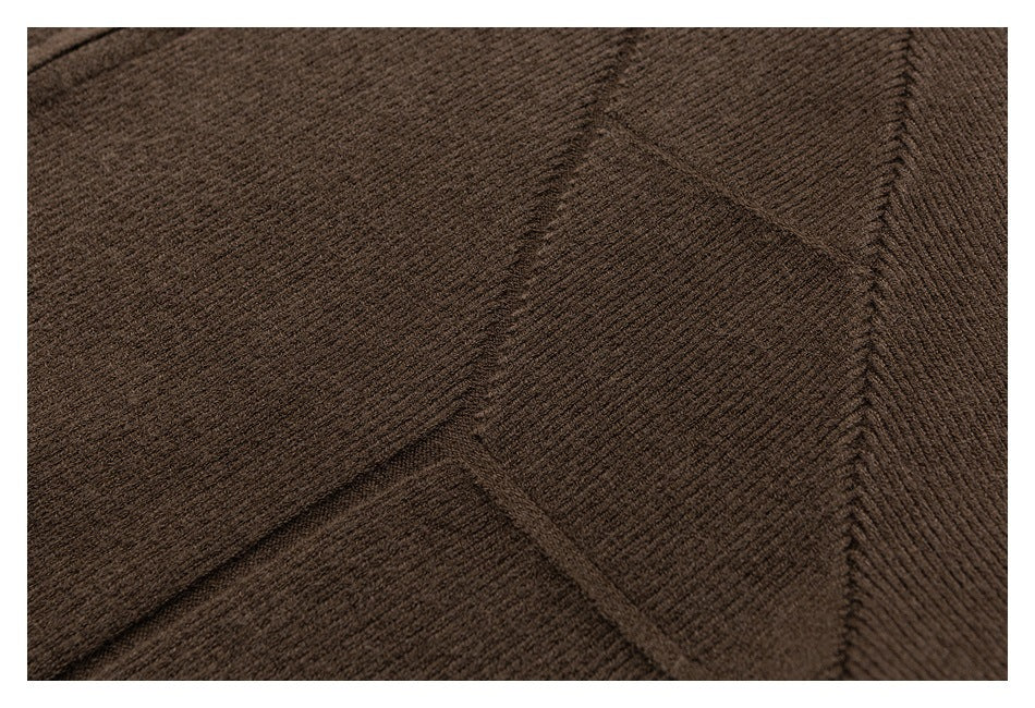 Close-up of brown knit fabric showing diagonal ribbing and a garment seam.
