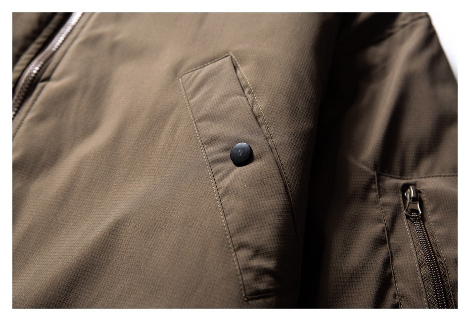 Close-up of a brown jacket showing a snap-button pocket flap and zippered pocket.