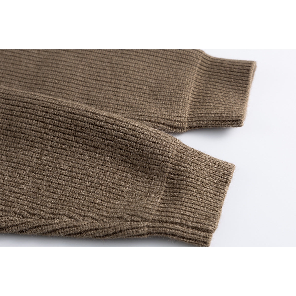 Close-up of two taupe-brown cardigan sleeves with ribbed cuffs.