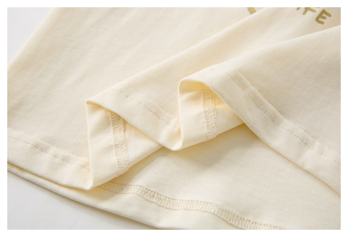 Close-up of cream fabric with folded edges and visible overlock stitching.