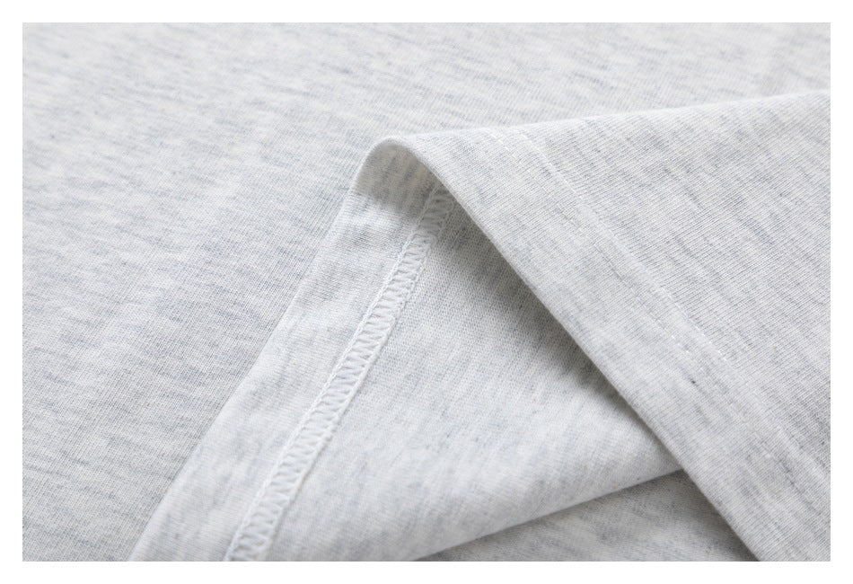 Close-up of light gray heather fabric with a stitched seam and folded edge.