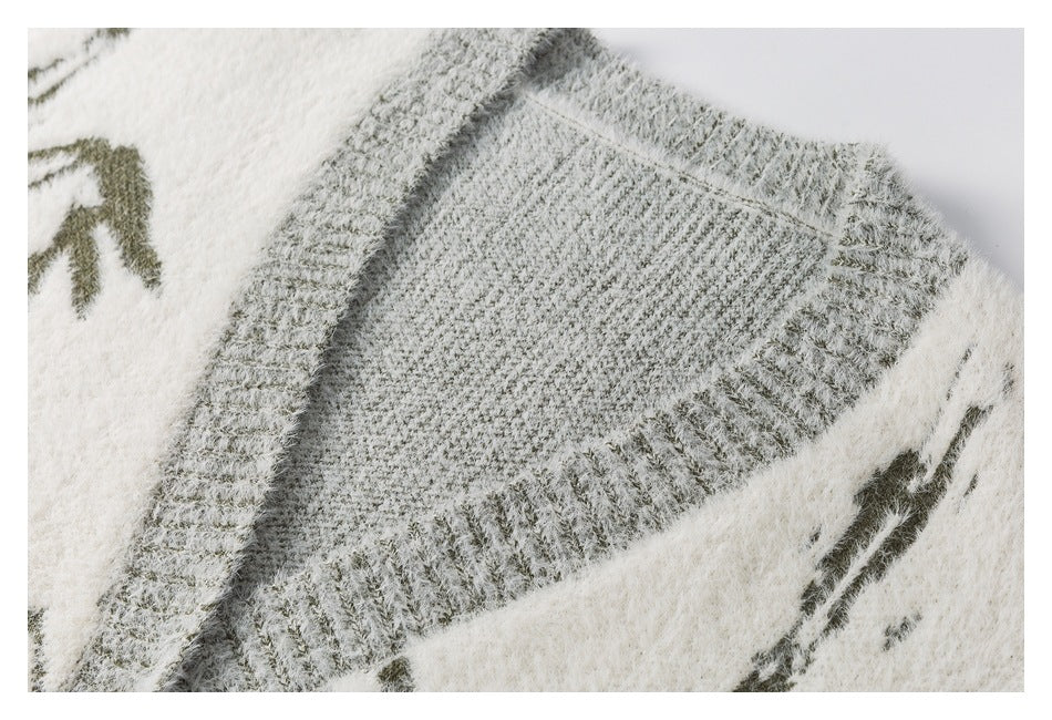 Close-up of an ivory cardigan's gray ribbed neckline and dark patterned knit.