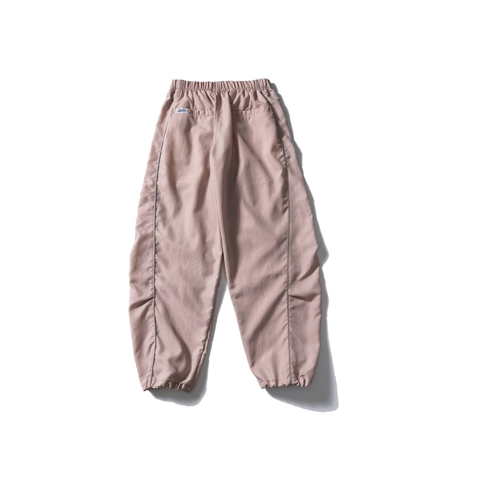 Full rear view of dusty mauve jogger pants with an elastic waist, back pockets, piped seams and gathered cuffs.