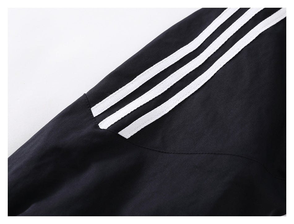 Close-up of three parallel white stripes on black fabric.