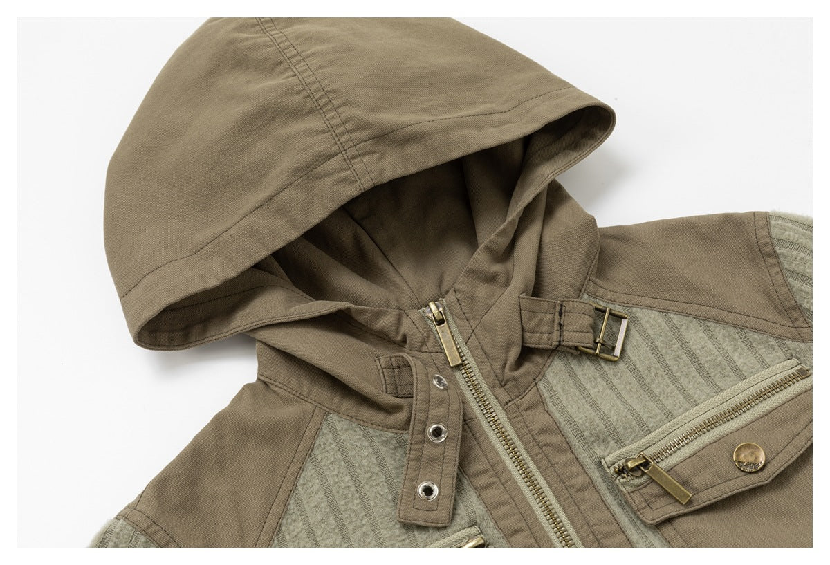 Close-up of the jacket's taupe hood, ribbed sage panels, front zipper and chest pocket hardware.