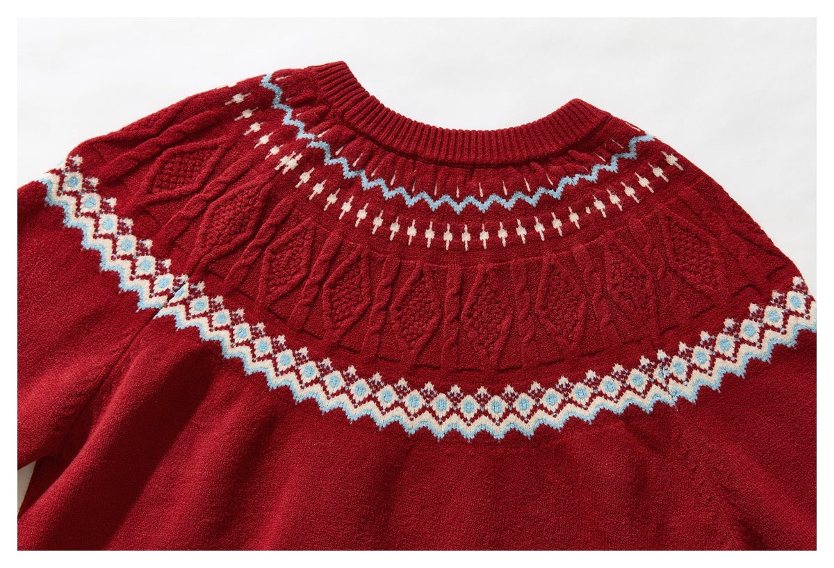 Back view of a red sweater laid flat, showing a textured yoke and cream-and-blue geometric bands.