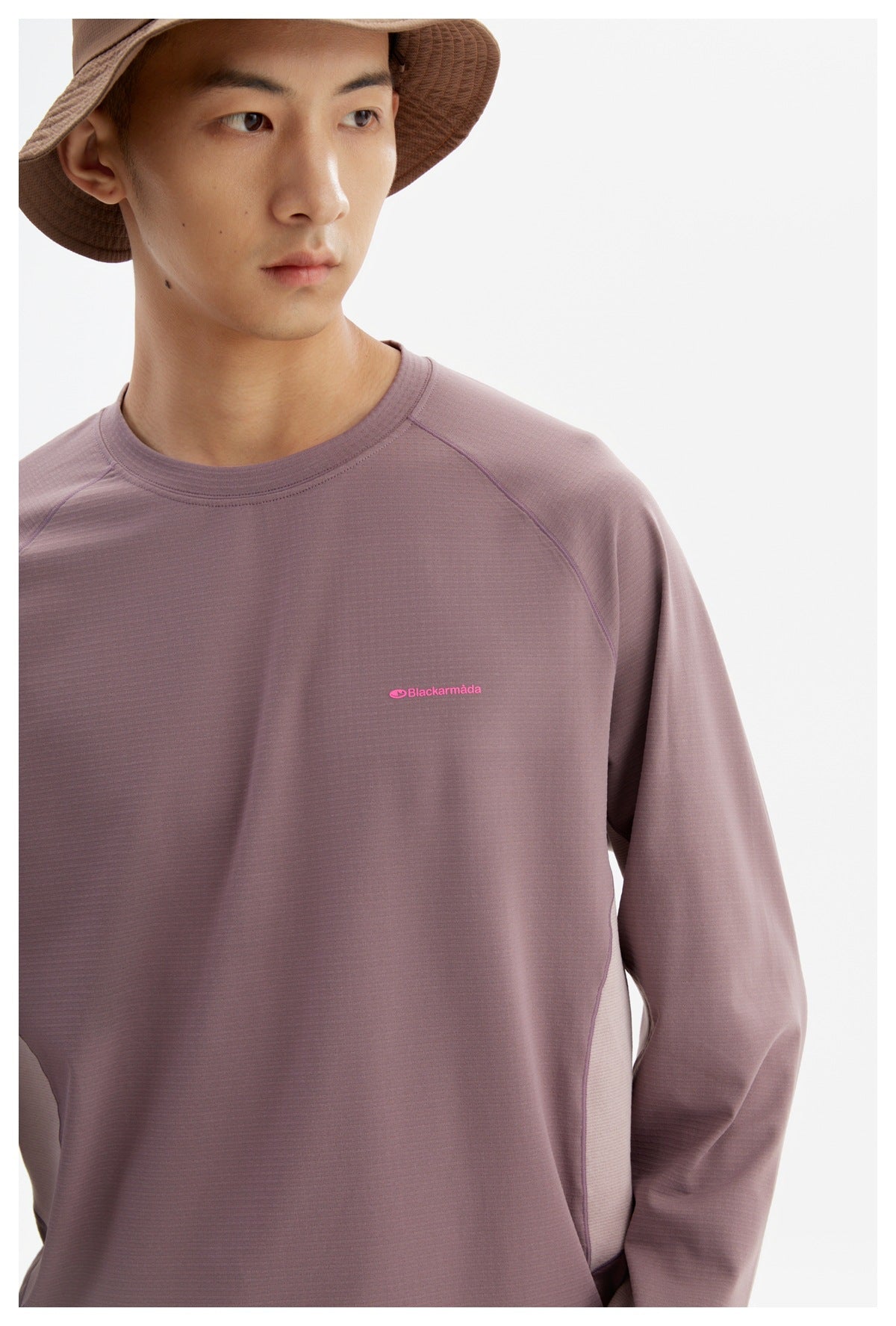 Close-up of the mauve shirt's crew neckline, raglan seams, fine texture, and pink chest logo.