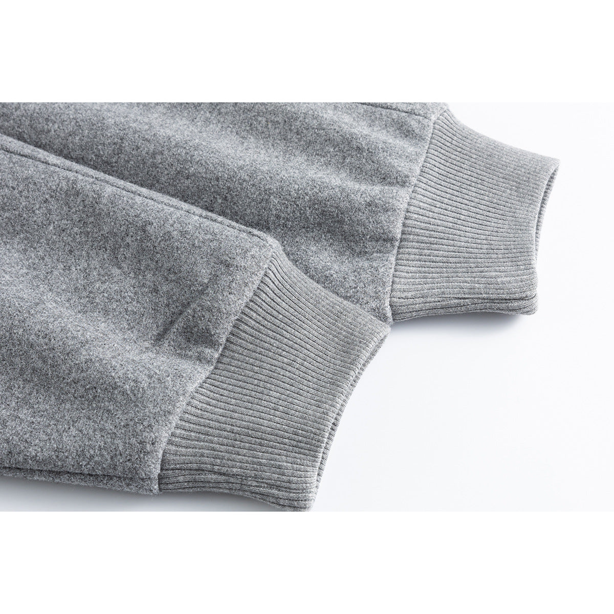 Close-up of a gray jacket sleeve and body with wide ribbed knit cuffs.