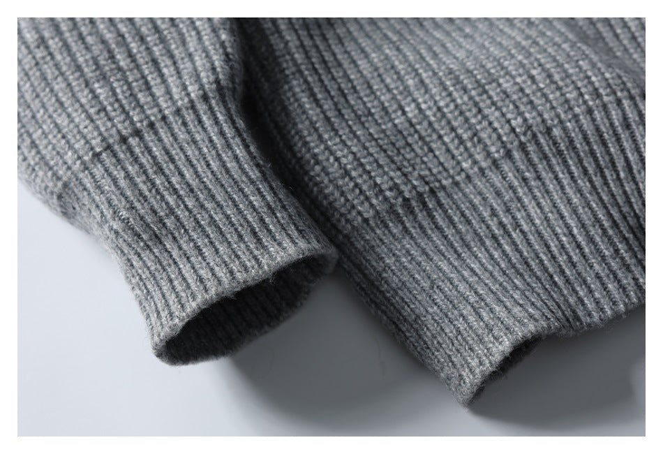Close-up of a gray ribbed knit sleeve cuff beside the garment hem.