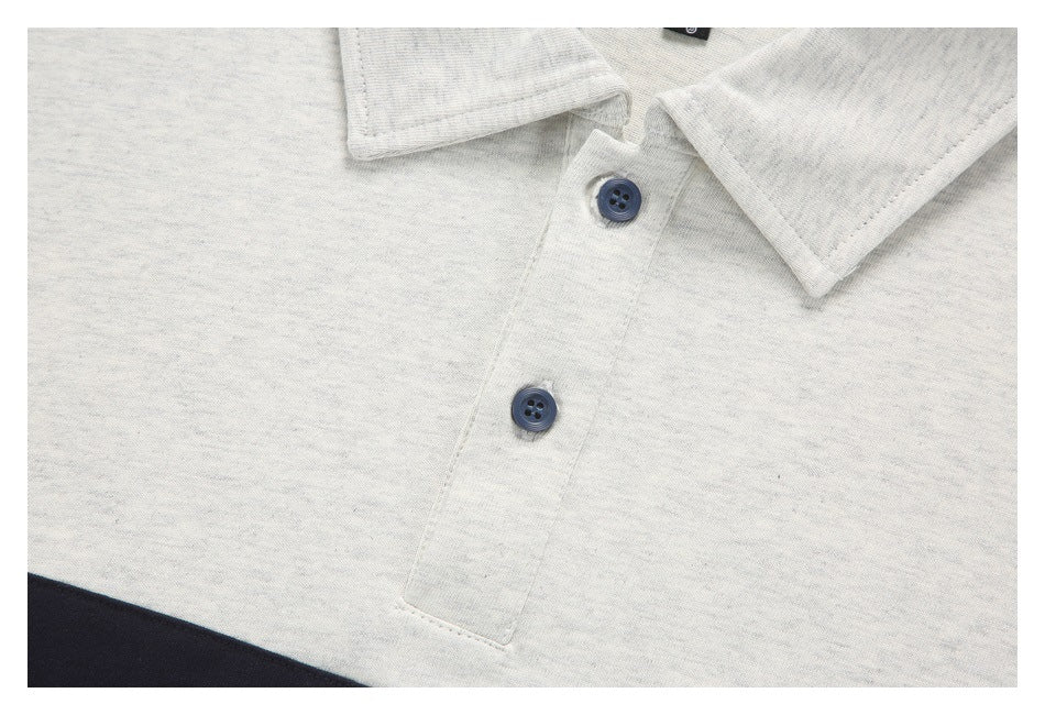 Close-up of the light gray polo shirt's collar, placket, and two dark buttons.