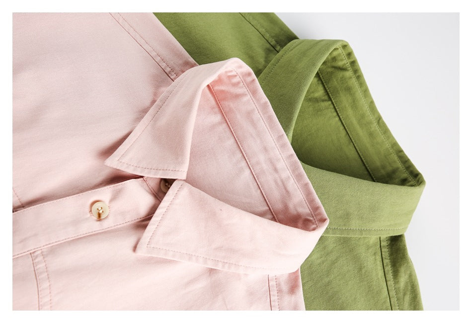 Close-up of pointed collars and button plackets on pale pink and olive-green shirts.