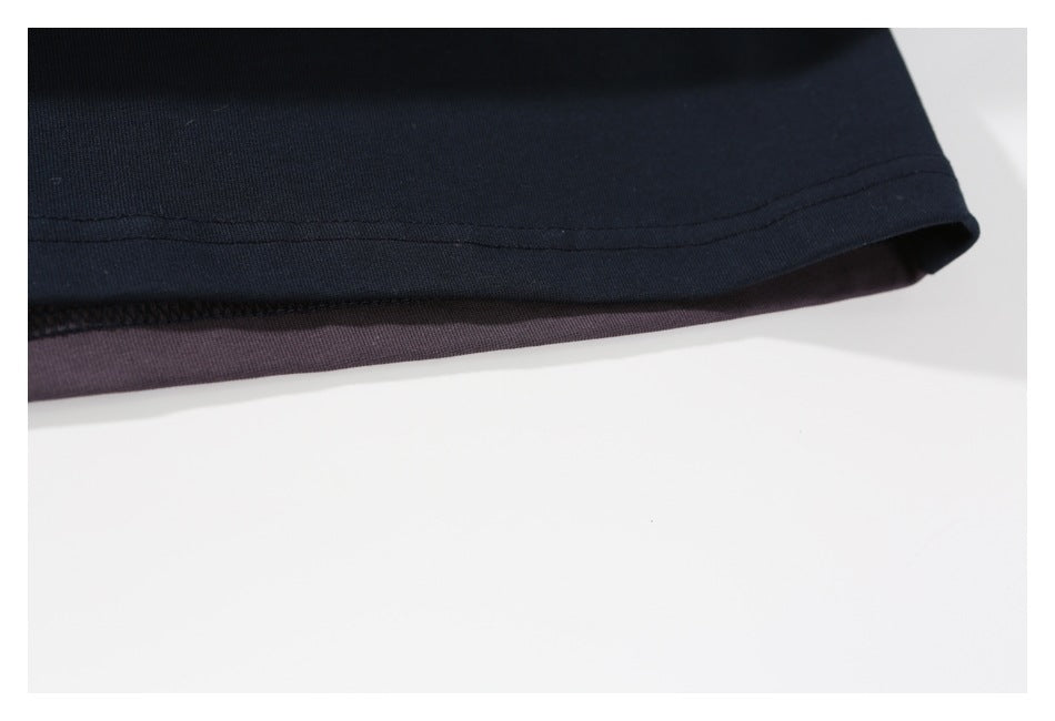 Close-up of a dark navy garment hem with stitching and a muted purple-gray inner layer.