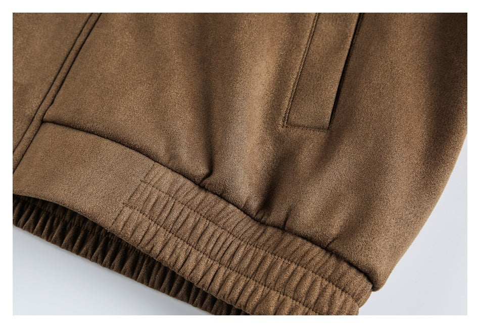 Close-up of the brown jacket's gathered elasticated hem and adjacent pocket opening.