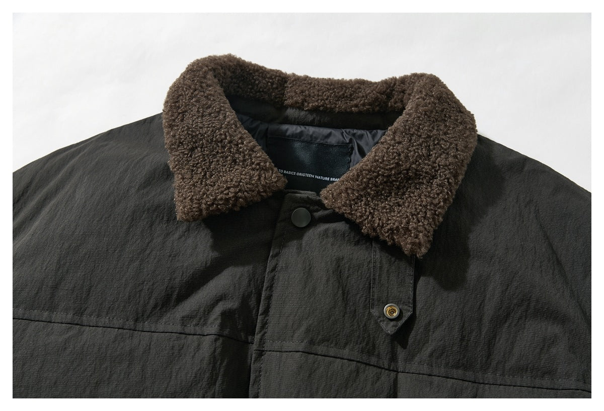Close-up of a dark jacket’s brown fleece collar, charcoal shell, and snap-button front placket.