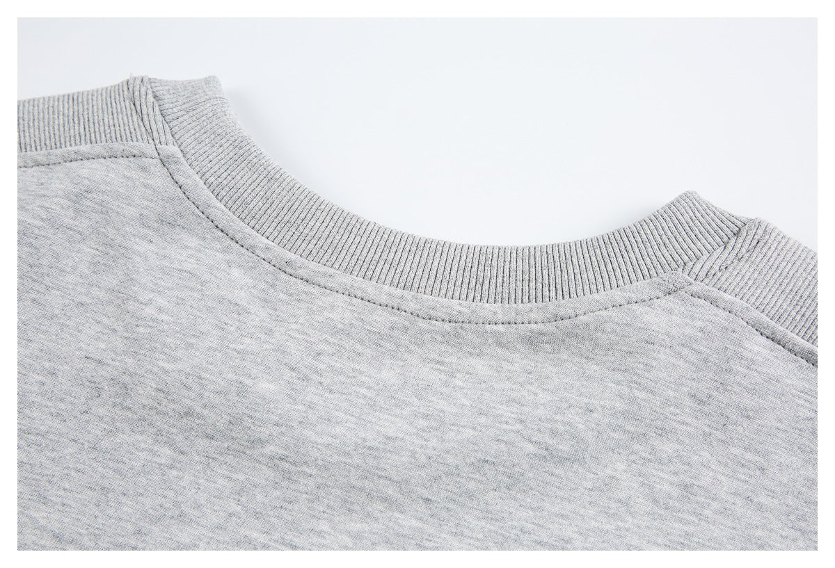 Close-up of a heather gray sweatshirt's ribbed crew neckline and shoulder seams.