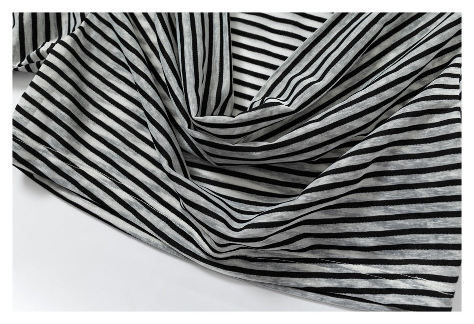 Close-up of a black-and-white striped garment draped to show its folds and horizontal stripe pattern.