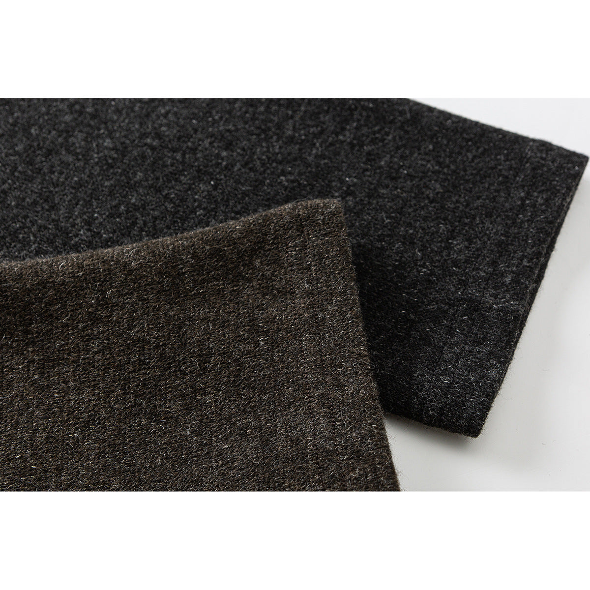 Close-up of overlapping dark charcoal and brown heathered garment fabric.