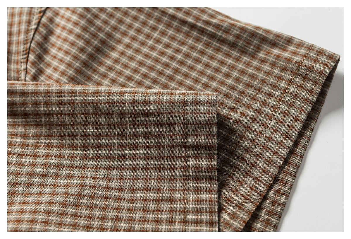 Close-up of the checked shirt sleeve and cuff, showing the fabric pattern and stitching.