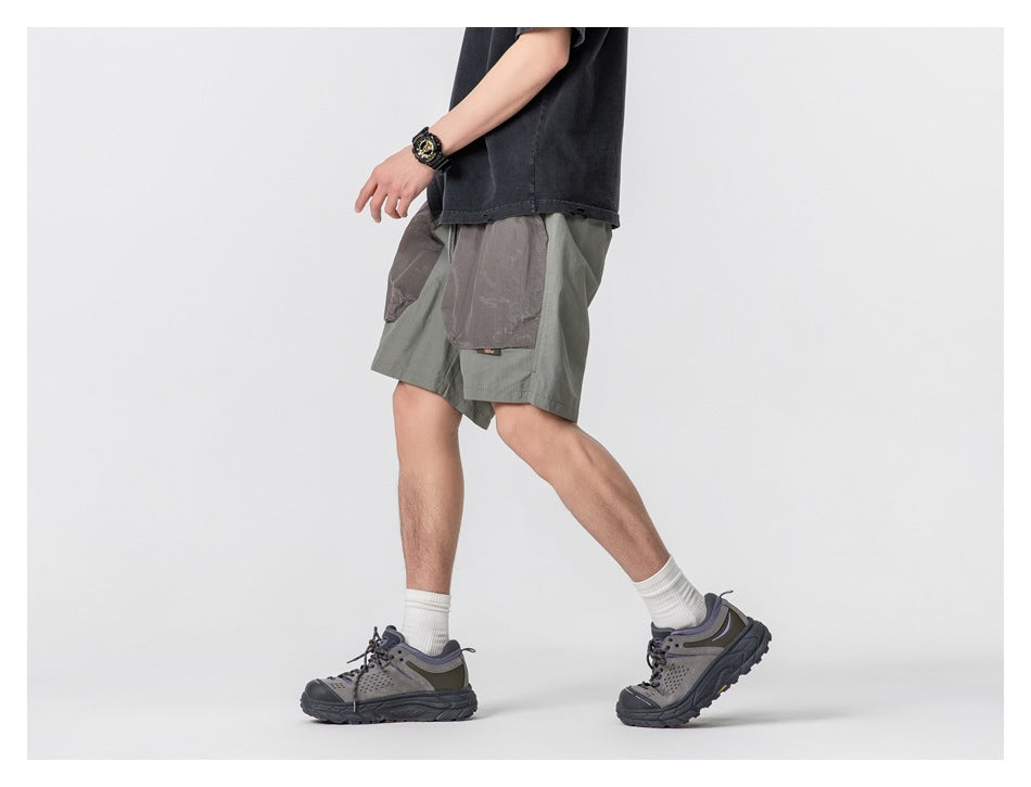 Side view of a person walking in sage gray shorts with large contrasting cargo pockets.