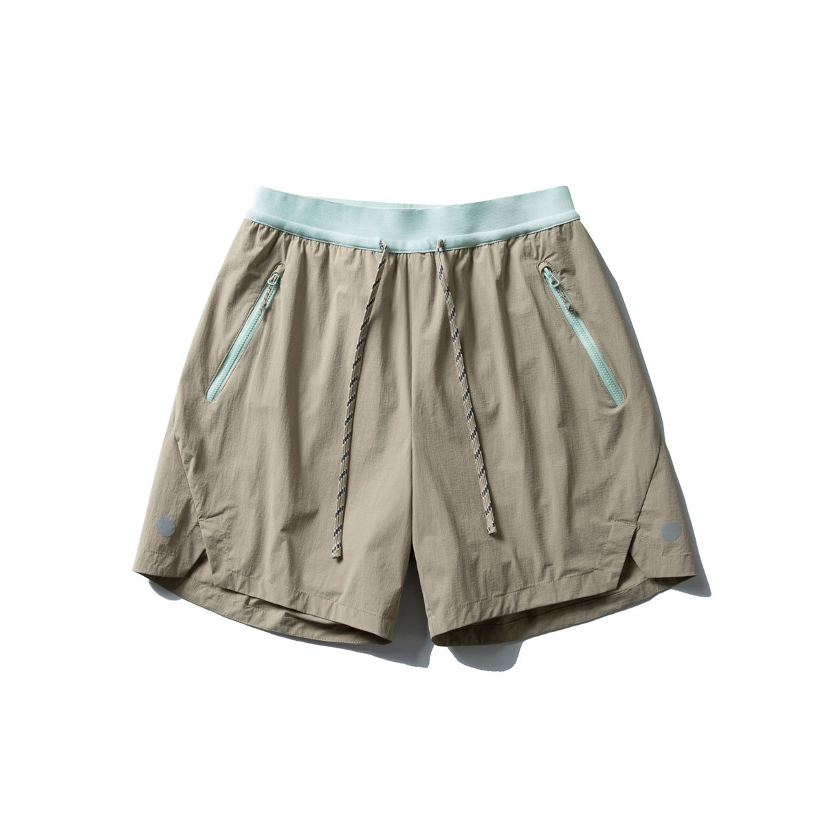 Khaki drawstring shorts with mint green waistband and mint zippered front pockets, flat lay