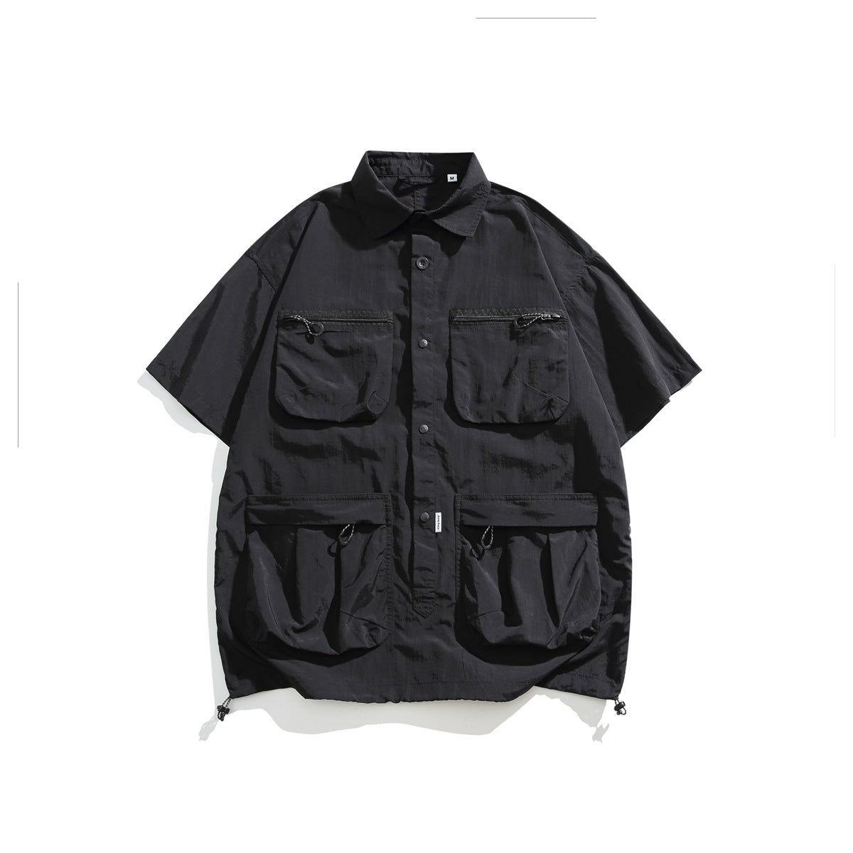 Black short-sleeve utility shirt flat lay with four flap pockets, button front and drawcord hem