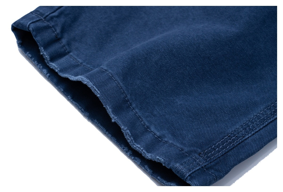 Close-up of a dark blue garment hem with visible stitching and a raw, frayed edge.