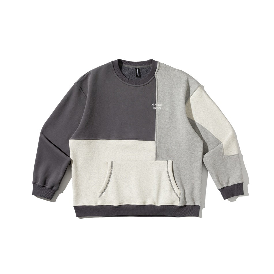 Flat-lay of a color-block crewneck sweatshirt in charcoal, light gray and oatmeal with a front pocket