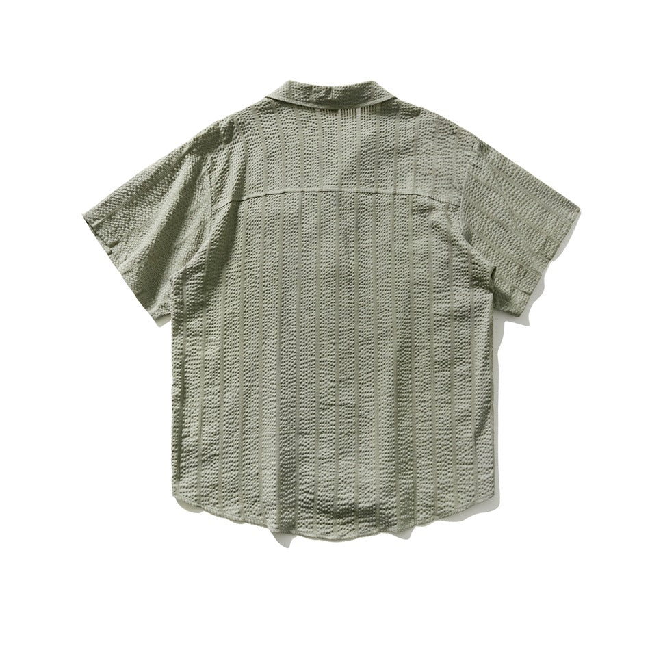 Back view of sage green short-sleeve shirt with textured vertical stripes, back yoke seam and curved hem