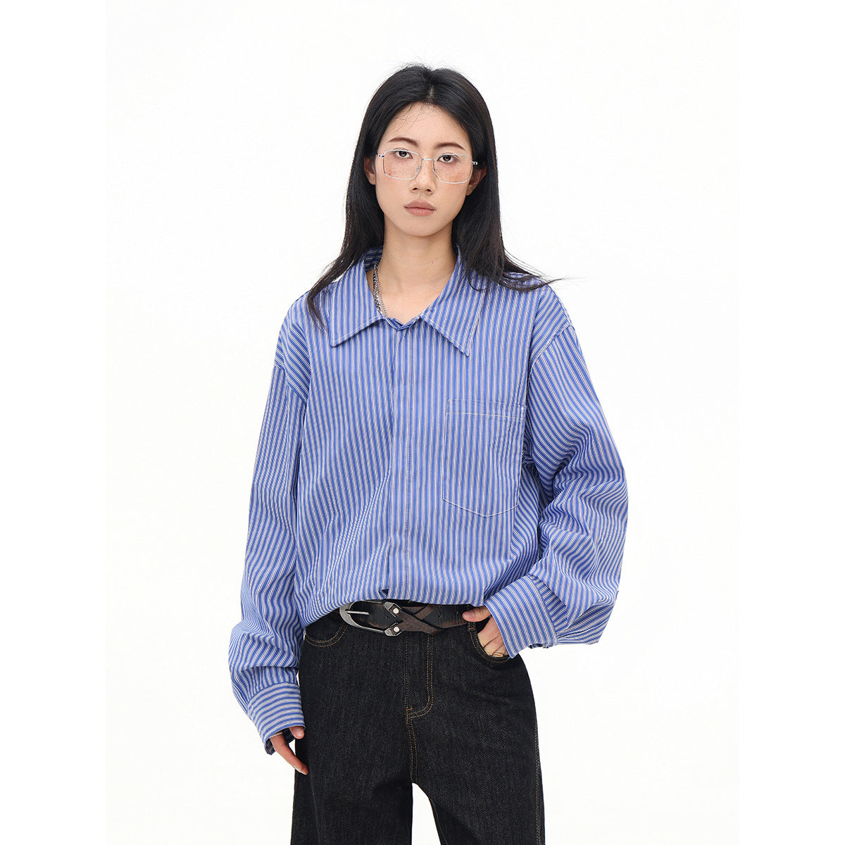 Model wearing an oversized blue-and-white striped collared shirt with long sleeves and a chest pocket.