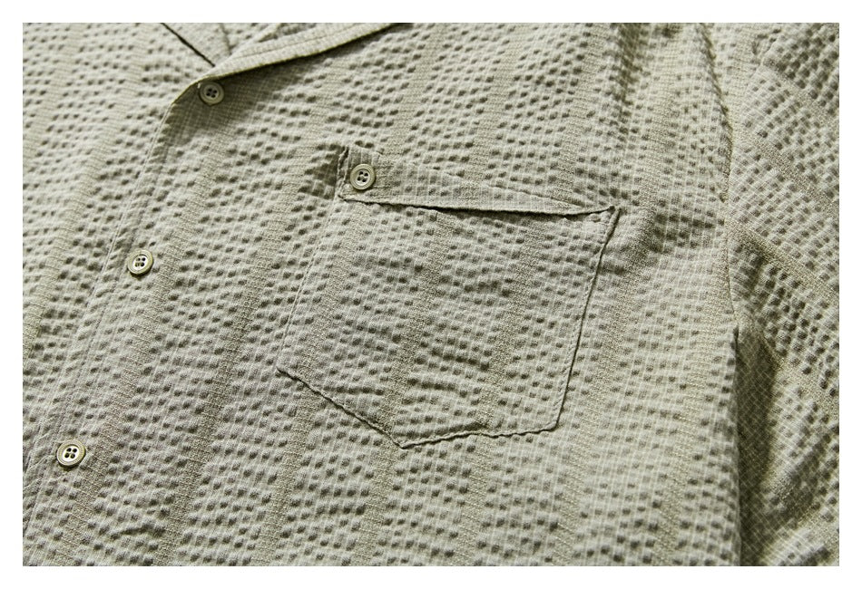 Close-up of the sage-gray shirt's textured front, buttons, and single chest pocket.