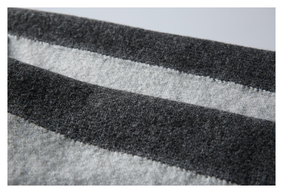 Close-up of alternating charcoal and light gray horizontal sweater stripes.