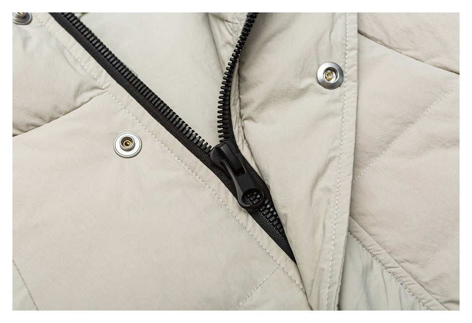 Close-up of the black front zipper and metal snaps on a light beige jacket.