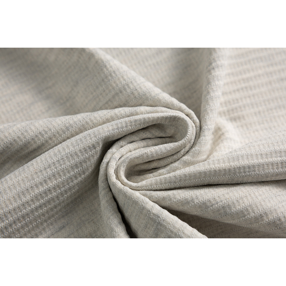 Close-up of light heather shirt fabric arranged in soft folds.