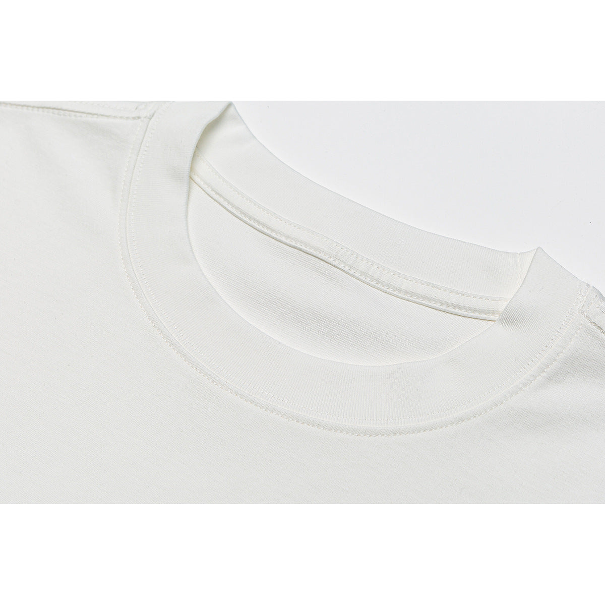 Close-up of a white T-shirt's ribbed crew neckline and shoulder seams.