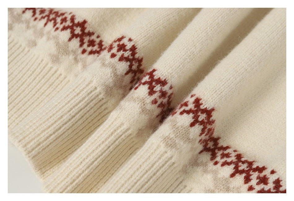 Close-up of a cream knit sweater with a rust-red geometric pattern and ribbed texture.