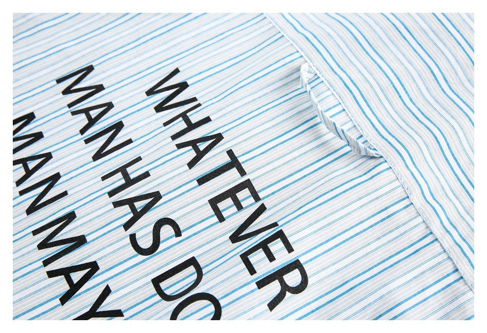 Close-up of white fabric with thin blue stripes and large black lettering.