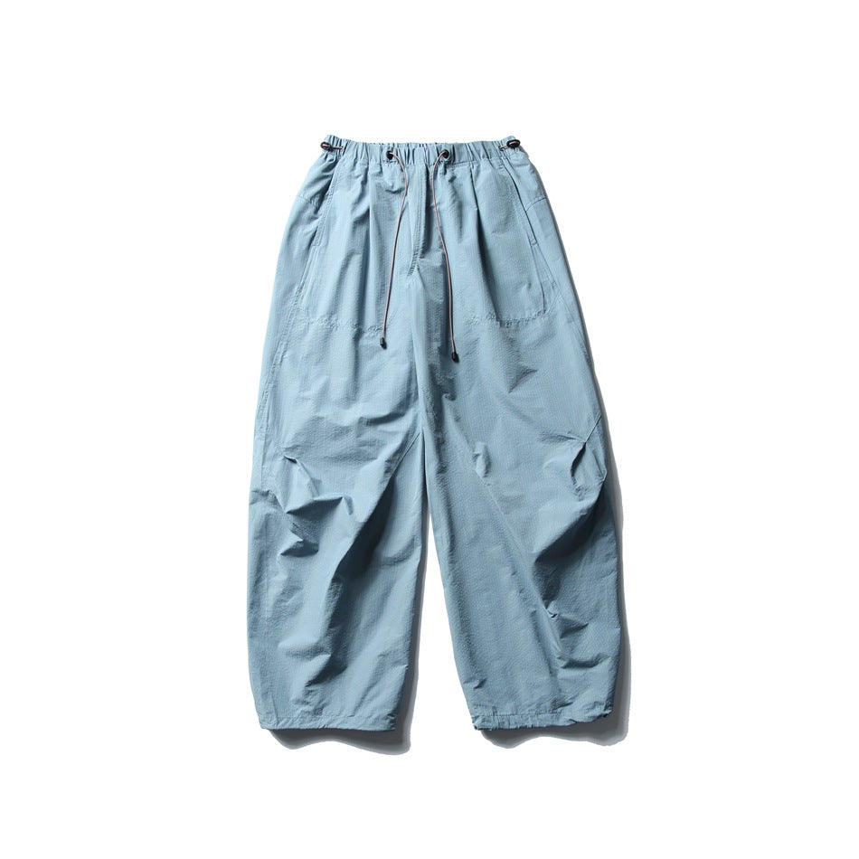 Light blue wide-leg parachute pants with drawcord elastic waistband, flat lay front view